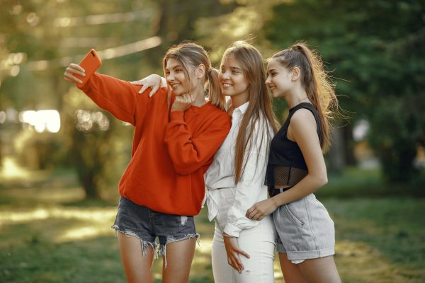 three friends taking a photo to post on social media
